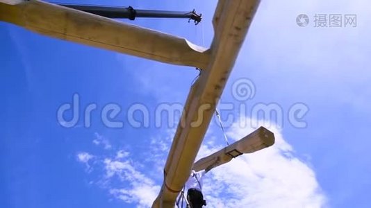 木屋面在晴天施工初期阶段.. 剪辑。 建筑工人用起重机的底视图视频