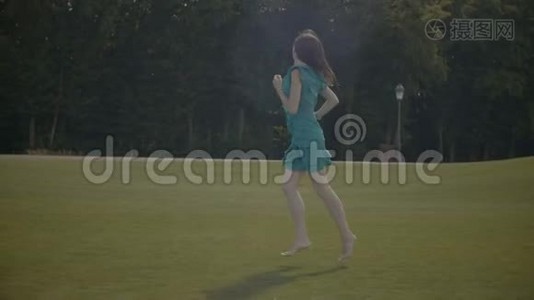 兴奋的赤脚女孩在绿茵场上奔跑视频