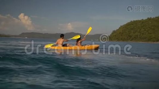 一对幸福的年轻夫妇在一个热带岛屿附近的黄色皮艇上玩得很开心视频