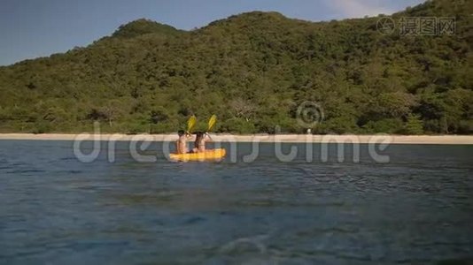 年轻人在黄色的独木舟上划着沙滩上的热带海滩，享受美好的假期视频