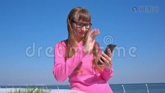 年轻女孩在智能手机上写短信视频