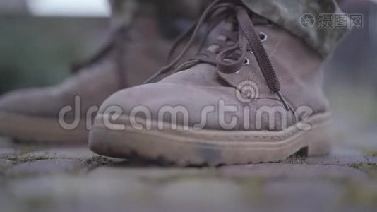 士兵`把靴子系紧. 鞋带随风飘扬.. 军靴在那人`脚上。 军事和视频