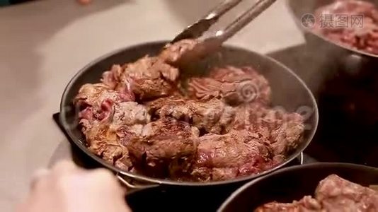 厨师在炒锅上炒肉，从盘子里蒸出来。视频