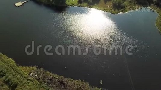 空中夏季景观的绿谷，小村庄，和湖面上的阳光反射。 股票视频