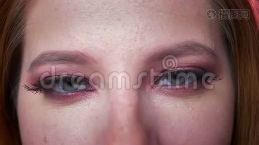 纯美的绿色眼睛在眼影靠近看镜头，白种人妇女站在黑色，示威视频