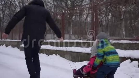 在寒假下雪的时候，父亲在街上橇着孩子视频