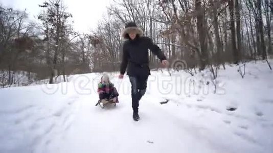 白雪森林里的幸福家庭，爸爸在冬天拉着儿子和女儿的雪橇视频