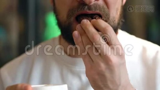 男人在咖啡馆里吃巧克力饼干和喝咖啡视频