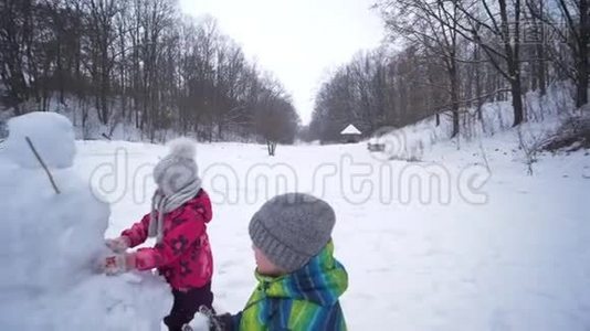 孩子们在寒假下雪的时候在雪地里堆雪人视频