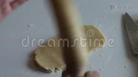 一个女人用木制的擀面杖在桌子上擀面视频