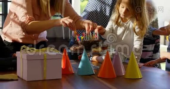 母亲和女儿在客厅4k的生日蛋糕上装饰蜡烛视频