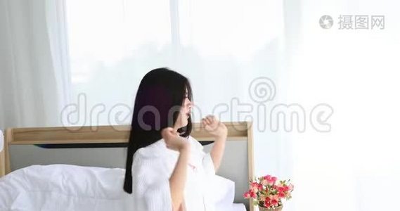 亚洲女人在卧室的床上伸展。视频