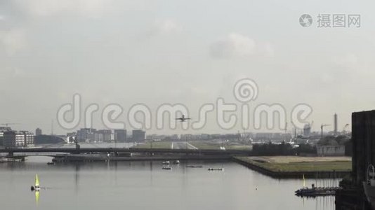 飞机飞过城市，桥和宽阔的河流上多云的天空背景.. 行动。 从地面起飞的飞机视频