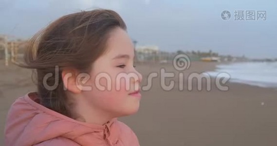 冬天一个女孩站在海滩上的画像视频