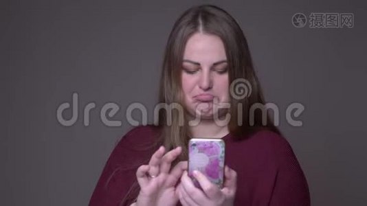 年轻超重的白种人女性手机短信特写，背景与灰色隔离视频