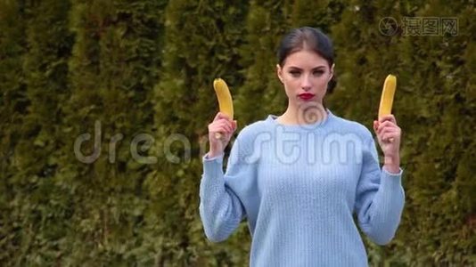 一位穿着蓝色夹克的迷人年轻女子像一样拔出香蕉，直接对着镜头拍摄视频