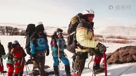 一队登山队员在一座大山陡峭的雪坡上停下来，检查你的路线。 他们的首领视频