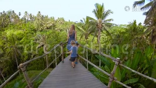 一个年轻家庭在一个大露台上自拍的慢镜头，可以看到丛林。 前往东亚旅游视频