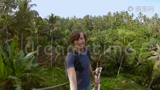 一个年轻人在一个大露台上拍自拍片，可以看到丛林视频