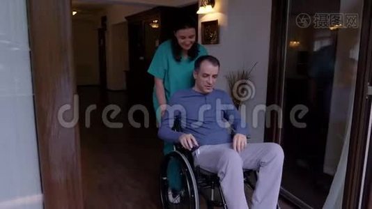 护理员和坐轮椅的年轻人来到露台上视频