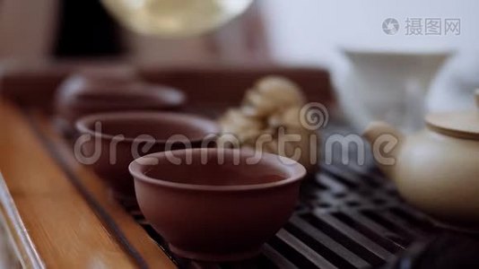 中国茶道，桌上是三杯，他们从一个水壶里倒出来。 特写视频