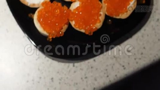 红鱼子酱是用勺子放在带有干酪的小馅饼上。 用红鱼子酱准备零食.. 上景。 框架视频