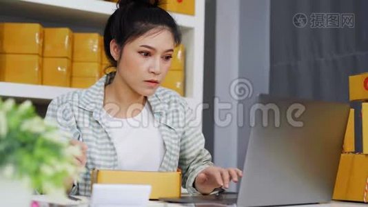 网上小企业主，带笔记本电脑的女性，准备包裹盒送货视频