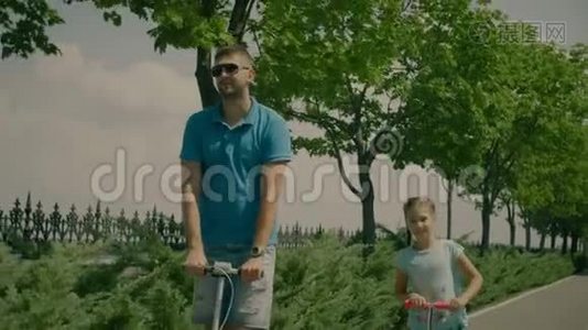 公园里有踢脚踏板车的现代家庭视频