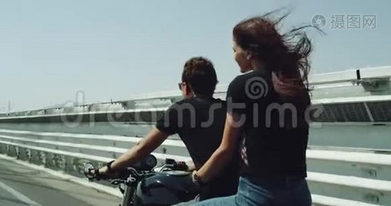 骑摩托车的特写情侣骑着摩托车他们夏天很开心，在高速公路上的女士抱着可爱的男人视频