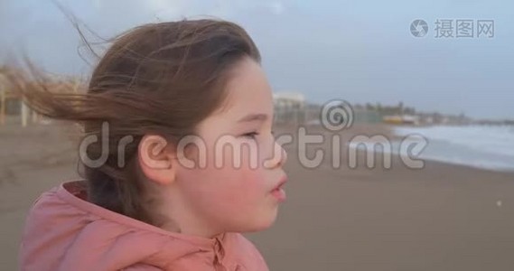 冬天一个女孩站在海滩上的画像视频