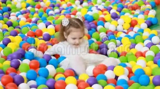 小女孩在操场上玩着五颜六色的气球。 宝贝为孩子们玩游戏。视频