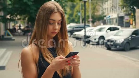 美女在手机上打字，背景是街上行人，棕色头发的女人看着视频
