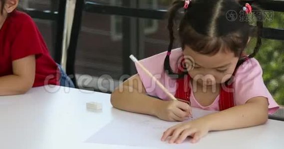 亚洲小女孩在美术课上有意识地画一些卡通。视频