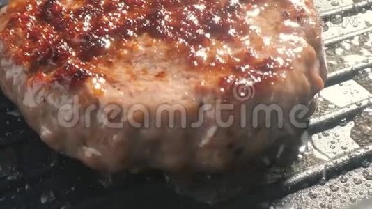 一个肥肥多汁的汉堡肉夹菜在烤架上准备好了，热和烟视频