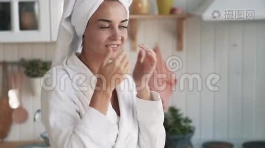 贴身，穿浴袍的女孩，头上有毛巾，脸上涂着奶油，动作缓慢视频