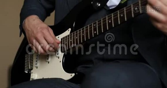 穿着深色衣服坐着演奏美妙的吉他爵士音乐的人。视频
