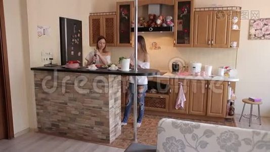 两个女同性恋在家里在现代化的厨房准备蔬菜沙拉。视频