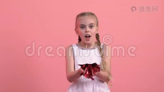 微笑的女孩从手中吹出心形纸屑，圣瓦伦丁节节日视频
