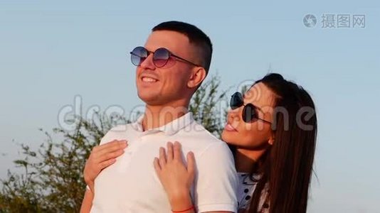 美丽幸福时尚欢乐年轻的欧洲可爱夫妇在黑色眼镜与美丽的微笑在彼此`的手臂。视频