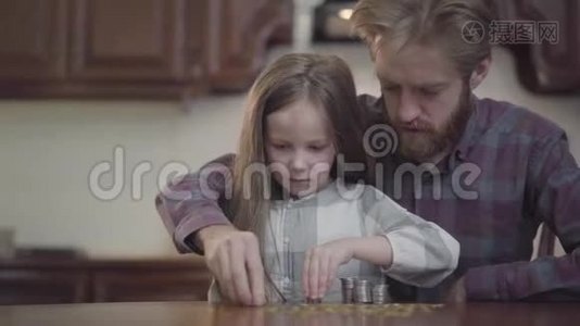 有胡子的男人坐在厨房的桌子旁，女儿在数钱。 穿格子衬衫的胡子视频