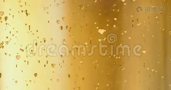 情人节金色的心形起来就像金色背景下的细碎香槟泡沫运动，节日的情人节视频