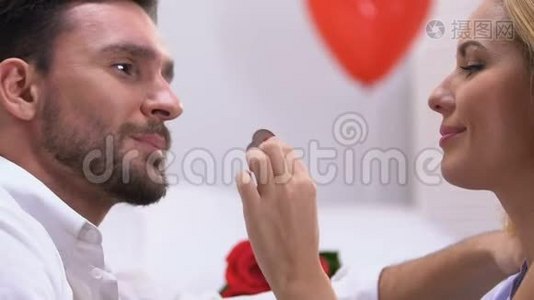 女人用巧克力勾引男人，用爱亲吻，浪漫的气氛视频