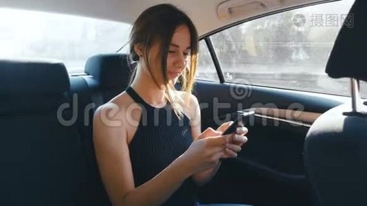 年轻女子在开车时使用她的智能手机。 女孩在骑车的时候检查指甲视频