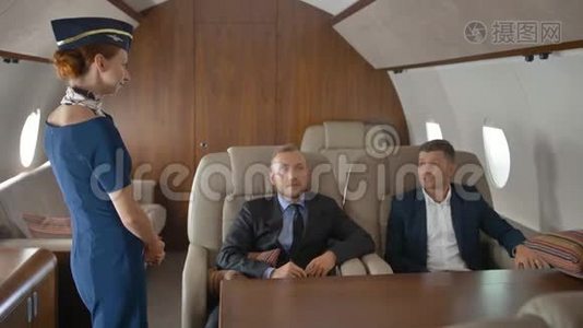企业家在私人飞机上放松飞行和与空姐交谈视频