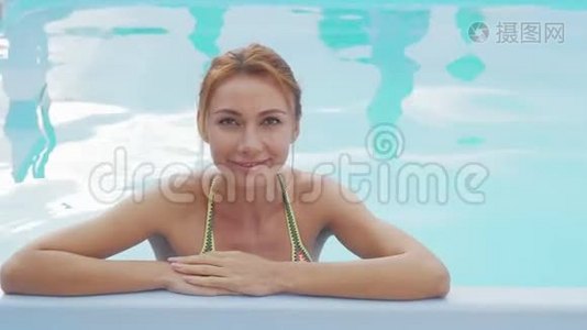 美丽快乐的女人微笑着在游泳池里放松视频