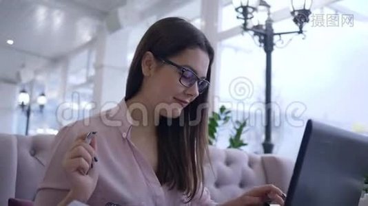 现代支付技术，成功的自由职业者女性使用笔记本电脑用信用卡支付互联网服务视频