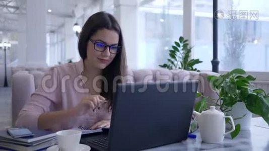 现代智能技术，快乐成功的女性在笔记本电脑工作时用手机拍照视频