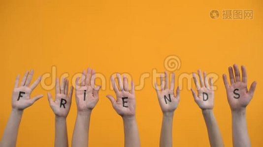 朋友用手掌写在橙色背景上，团结联系，帮助视频