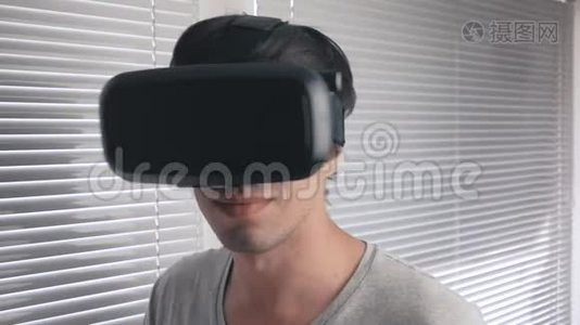 年轻人用他的VR耳机在办公室背景下观看360视频。 快关门。视频