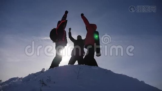 阿拉斯加的旅行者来到雪山的山顶，为战胜冬日的日落而欢欣鼓舞。 人的团队工作视频